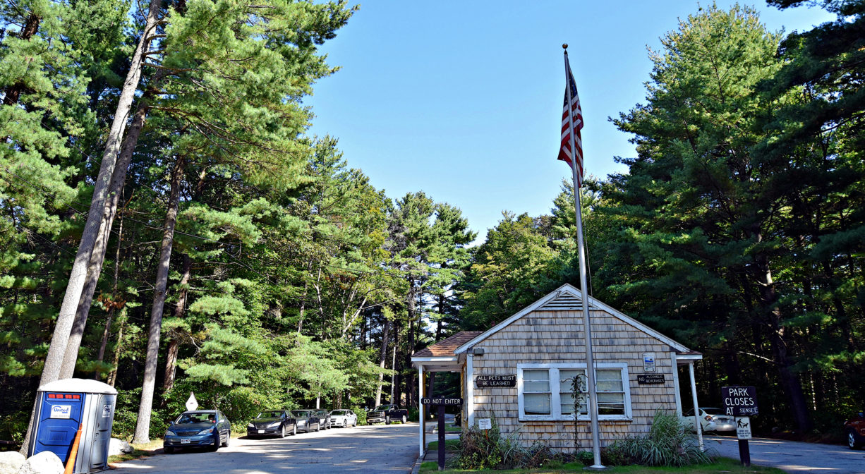 A photograph of a park entrance in a wooded setting.