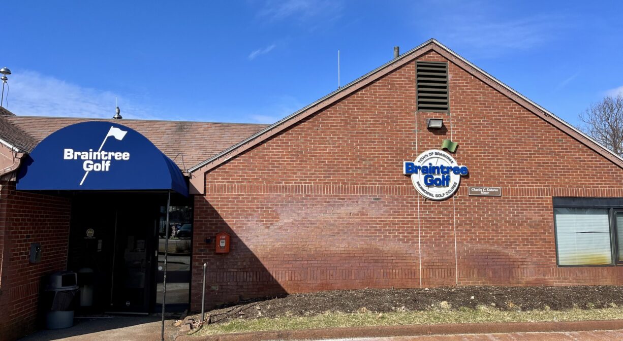 A photograph of a brick clubhouse at a country club.